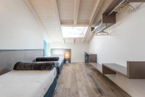 Pokój z 3 łóżkami i świetlikiem w obiekcie Casa Tonetta Luxury Apartments w Arco