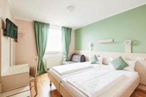 een slaapkamer met een groot wit bed en een stoel bij Hotel Imperial in München