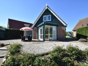 a house with a patio and an umbrella at Modern Holiday Home in Ooltgensplaat in Ooltgensplaat