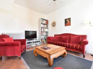 a living room with two red couches and a coffee table at Apartment with south facing balcony in Yèvre-le-Châtel