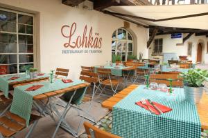 un restaurant avec des tables et des chaises et un panneau sur le mur dans l'établissement Le Lohkäs - LOFT Triplex Ultra Design Petite France, à Strasbourg