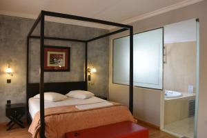 a bedroom with a four poster bed and a tub at Villa Orion Hotel in Athens