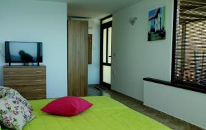 a bedroom with a green bed with a red pillow at Happy beach in Varna City +45 photos
