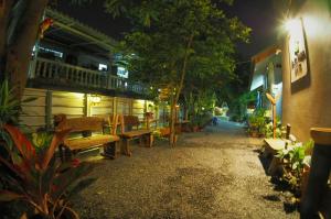 eine Gruppe von Bänken, die nachts vor einem Gebäude sitzen in der Unterkunft Pan Din Boutique Guest House in Phra Nakhon Si Ayutthaya