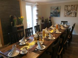 a long wooden table with chairs and plates and napkins at Ferienwohnung Schmitz in Serrig