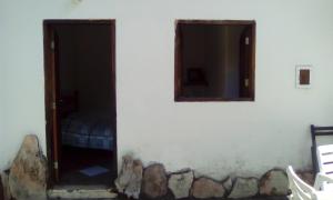 a room with a door and two windows on a wall at Pousada Chalés do Lago in Cavalcante