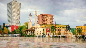 un edificio con una torre de reloj en una ciudad en Elisabet Tirana, en Tirana