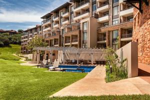 an apartment building with a swimming pool in a yard at Zimbali Suite 113 in Ballito