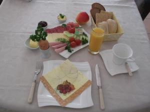 Haus am Wald في Guhrow: طاولة عليها أطباق من المواد الغذائية والمشروبات