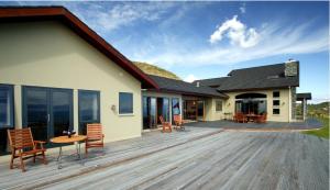 a wooden deck with chairs and a house at Parautane Lodge in Nelson