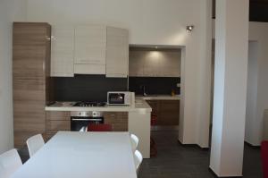a kitchen with white cabinets and a white table with a white table at Casa delle mimose in Varazze