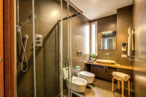 a bathroom with a shower and a toilet and a sink at Trevi Beau Boutique Hotel in Rome