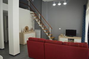 a living room with a red couch and a staircase at Casa delle mimose in Varazze