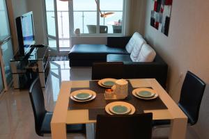 a living room with a table and a couch at Silver Beach Delux Apartment in Byala