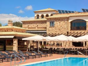 ein Resort mit einem Pool mit Stühlen und Sonnenschirmen in der Unterkunft Hapimag Resort Mas Nou in Platja  d'Aro