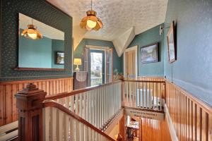 eine Holztreppe in einem Haus mit einem Spiegel in der Unterkunft À L'Ancestrale B&B in Magog-Orford