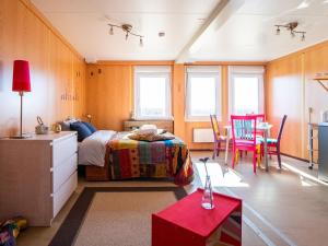 a bedroom with a bed and a table and chairs at Ytra Lón Farm Retreat in Þórshöfn