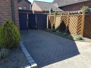 a driveway with a wooden fence and a gate at FeWo-Nordwalde in Nordwalde