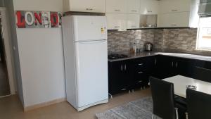マフムトラールにあるAtmaca Apartment 13のキッチン(白い冷蔵庫、黒いキャビネット付)