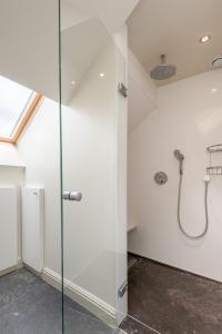 un baño blanco con cabina de ducha de cristal en Dendernachten, en Dendermonde