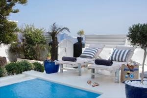a group of chairs sitting next to a swimming pool at Santorini Secret Suites & Spa, Small Luxury Hotels of the World in Oia