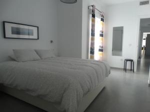 biała sypialnia z łóżkiem i stołem w obiekcie Málaga Apartamentos - Jinetes, 10 w Maladze