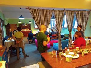a group of people sitting at tables in a restaurant at Hostel Flores in Kostanjevac