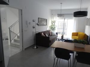 salon z kanapą i stołem w obiekcie Málaga Apartamentos - Jinetes, 10 w Maladze