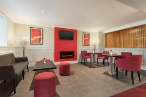 チョーリーにあるRamada Chorley Southの暖炉のある待合室(テーブル、椅子付)