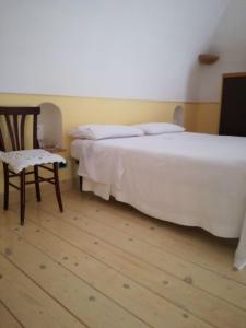 マッサ・ルブレンセにあるCasa Vacanze Massa Lubrenseのベッドルーム(白いベッド1台、椅子付)