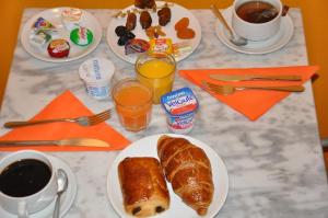 a table with a breakfast of croissants and coffee and juice at Europe Hotel Vieux Port in Marseille