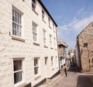 een vrouw die in een straat naast een gebouw loopt bij Little Dolly sea view 2 bedroom apartment, St Ives town, dog friendly in St Ives