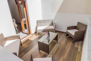 un soggiorno con sedie, tavolo e finestra di Suite Bordonaro Apartments a Cefalù