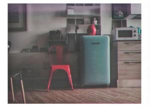 a kitchen with a red chair and a refrigerator at Casa Margherita in Modica