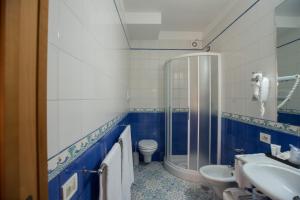 a blue and white bathroom with a toilet and a sink at Hotel Villa Maria in Sorrento