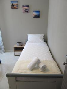 Sweet Home Glikadi في لايميناس: سرير عليه منشفة في الغرفة