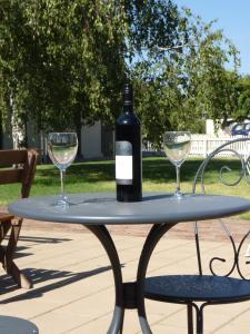 a bottle of wine sitting on a table with two glasses at Coonawarra Motor Lodge in Penola