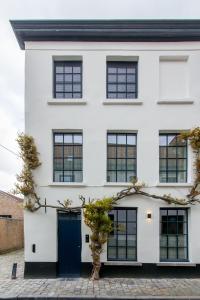 a white house with black windows and a blue door at Friday Gent in Ghent