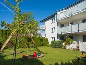 a garden with a tree swing in front of a building at Pension Maiglöckchen in Ostseebad Karlshagen