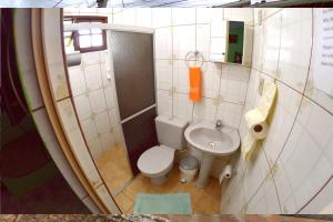 Baño pequeño con aseo y lavamanos en Pousada e Hostel Chapada Suites, en Lençóis