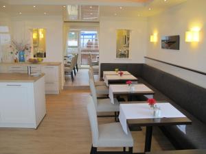 un ristorante con tavoli, sedie e bancone di Miramar a Helgoland