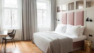 Schlafzimmer mit einem großen Bett mit einem rosa Kopfteil in der Unterkunft Hotel Zipser in Wien