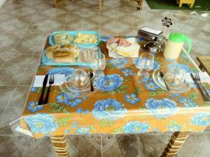 a table with a table cloth with blue flowers on it at Cantinho da Rapha in Ilha de Boipeba