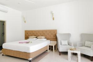 a bedroom with a bed and a couch and a chair at Nuga Eden Tangalle in Tangalle