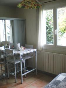 a kitchen with a table in a room with windows at Chez Annick in Guérande