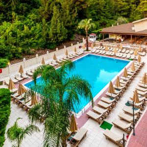 an overhead view of a pool with lounge chairs and a resort at Julian Forest Suites in Marmaris