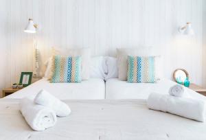 um quarto com 2 camas brancas com toalhas em BYPILLOW Mumm em Vilanova i la Geltrú