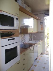a kitchen with a microwave oven and a sink at Villa "Le Mirage" in Cap-Ferret