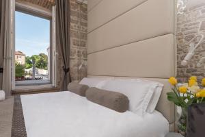 a bedroom with a white bed and a window at Zara Palace - design rooms in Zadar