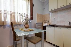 ブドヴァにあるDo Re Mi Apartmentsのキッチンにテーブルと椅子がある